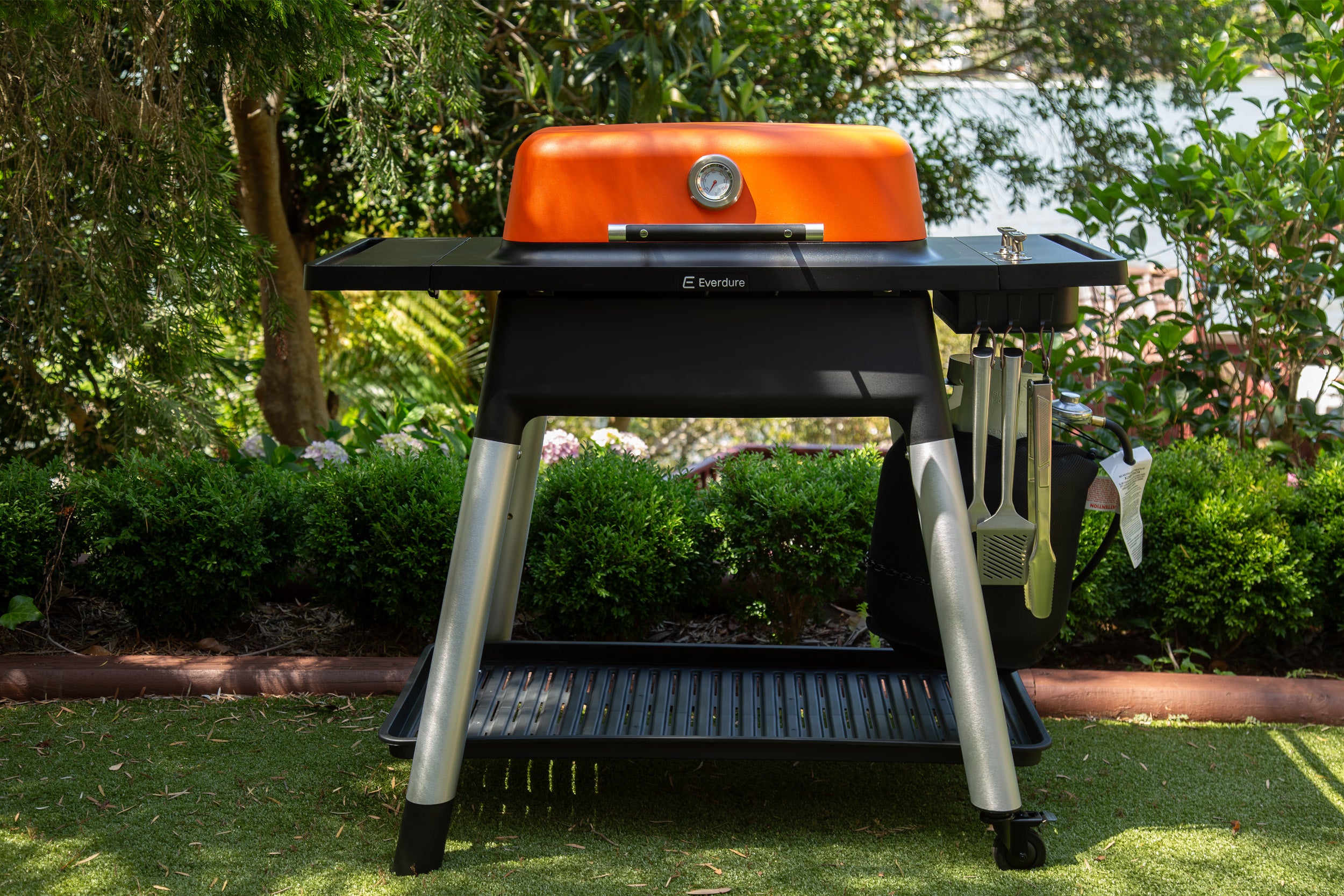 Black and orange barbecue grill in a garden setting